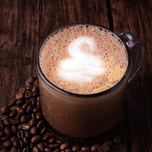 Coffee latte in a mug with a swan designed on the froth